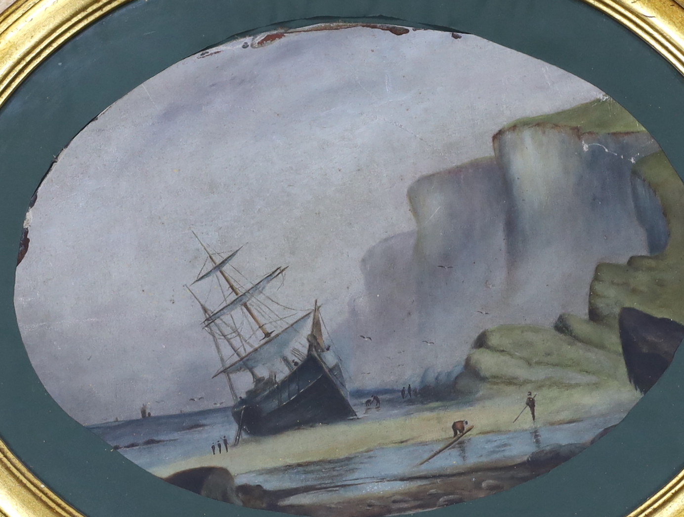 Late Victorian School, oval oil on unstretched canvas, Beached ship before cliffs, 40 x 28cm